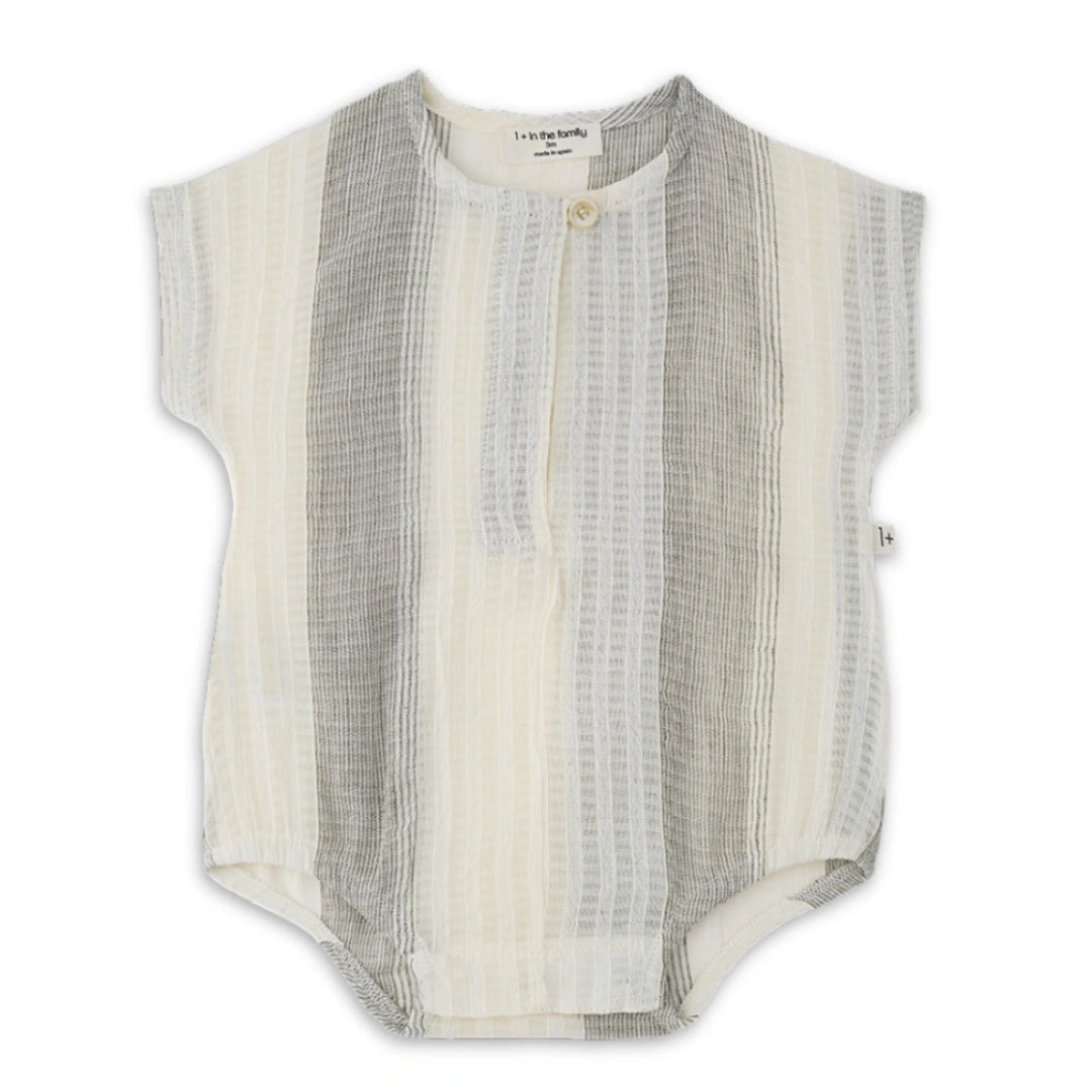 A high-end 1+ in the Family Bordils Romper in a soft neutral textured knit, featuring a modern architectural silhouette for infants.