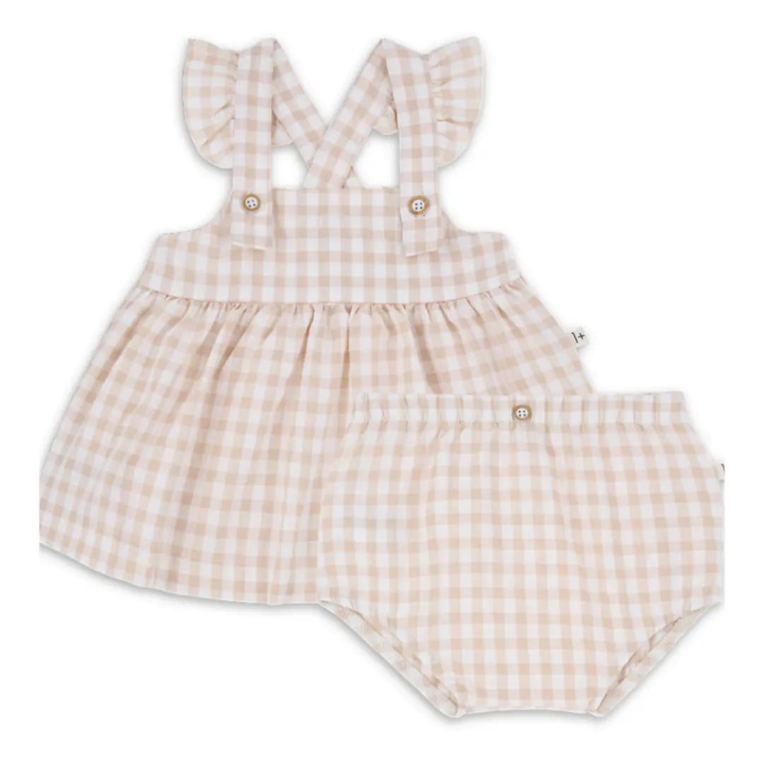 A sophisticated 1+ in the Family Rhodes Dress and matching Bloomer set in a soft neutral tone, showcasing its architectural silhouette and luxe texture.