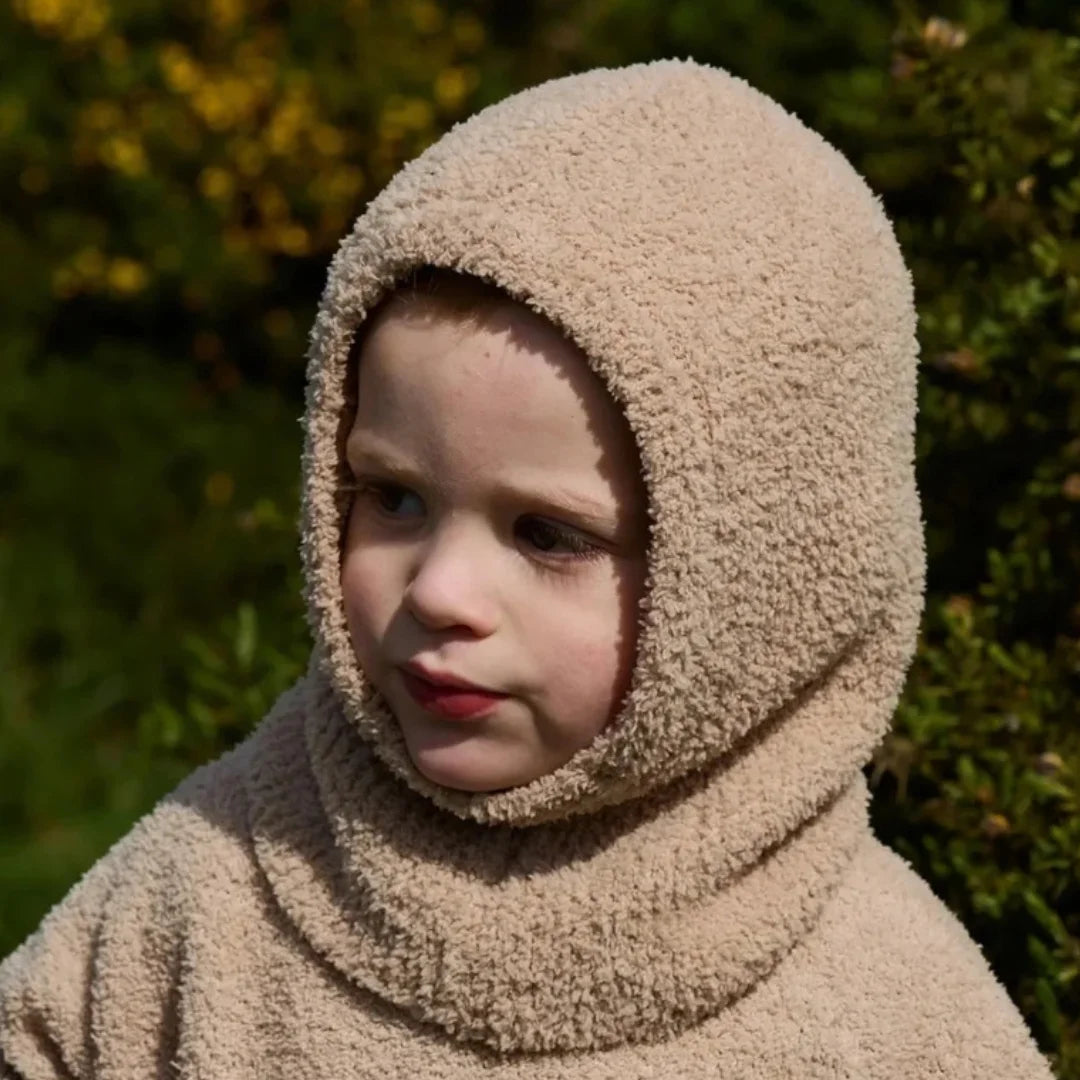 A child wearing the 7AM Enfant fleece bonnet comfortably