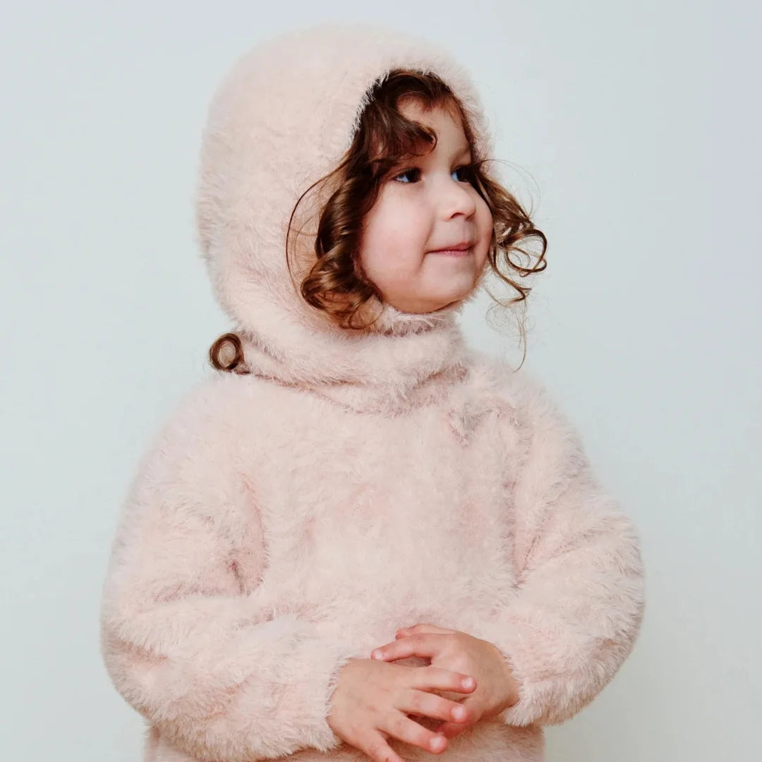 A child wearing the 7AM Enfant fleece bonnet comfortably