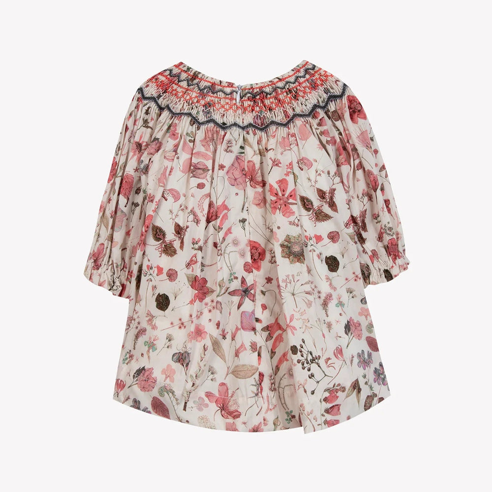 Floral blouse with smocked neckline on a white background