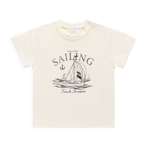 Beige t-shirt with sailing graphic and text on a white background