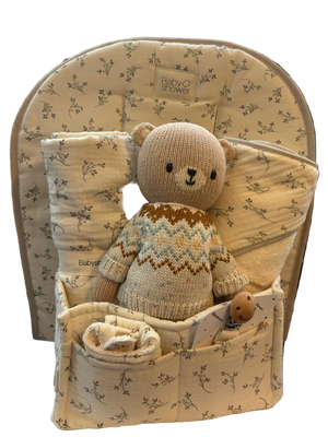 Baby seat with teddy bear and blanket in a store setting