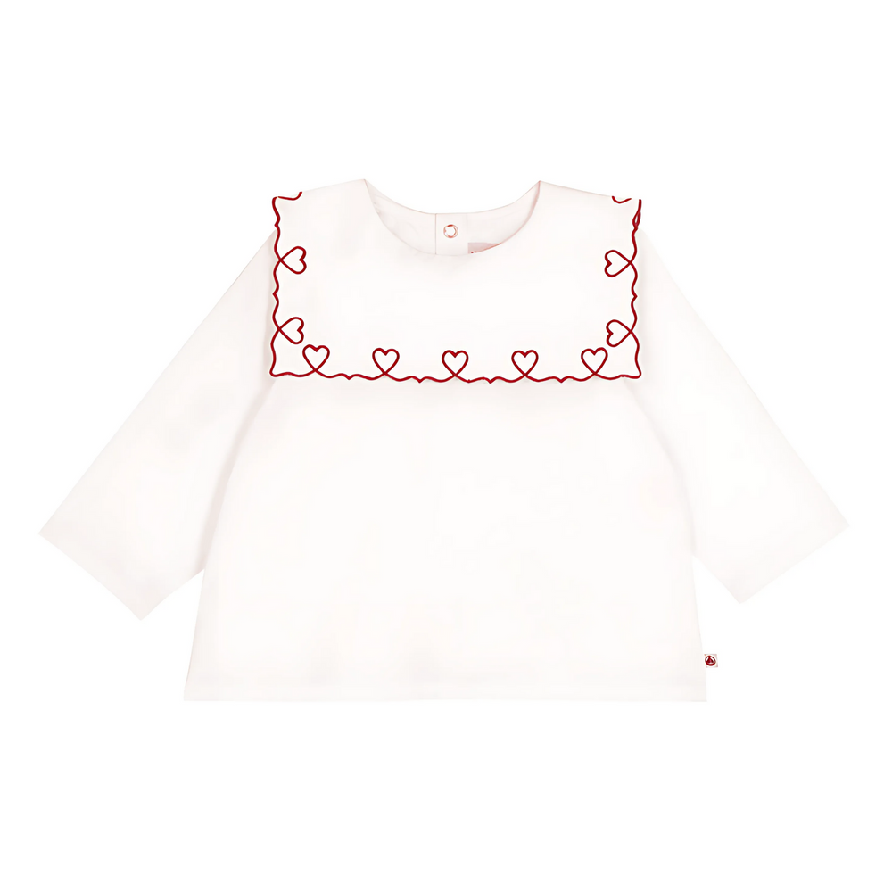 White long-sleeve top with red heart embroidery on a white background