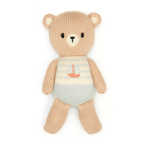 Knitted teddy bear with a sailboat design on a white background