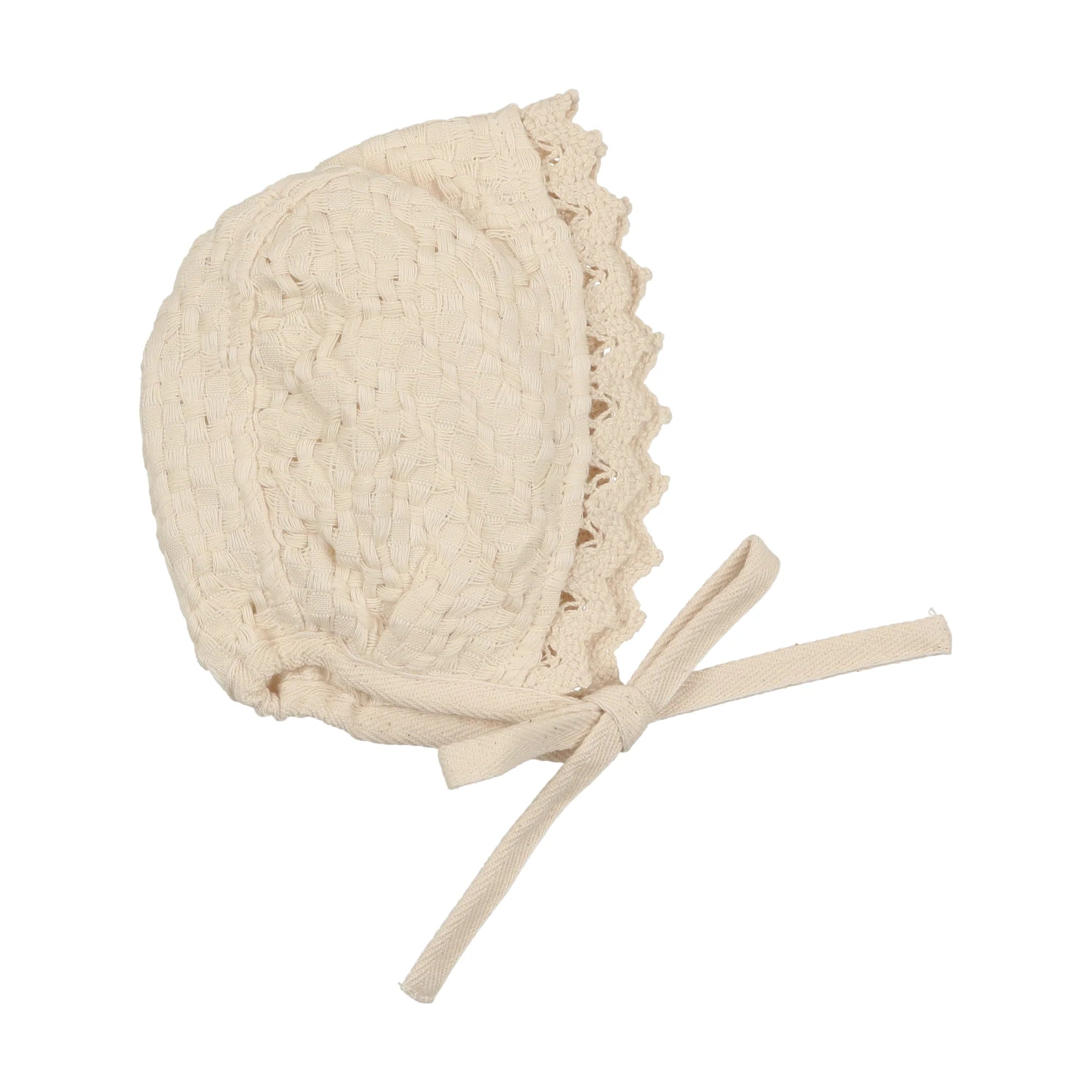 An off-white cotton muslin bonnet with a textured knit pattern, scalloped lace trim, and adjustable tie strings, shown on a plain white background.