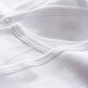 Close-up of a white baby outfit with a collar and buttons.