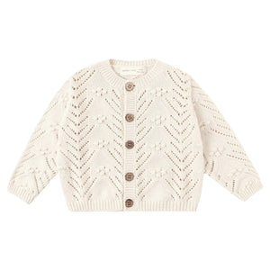 Cream-colored knitted cardigan with button details on a white background