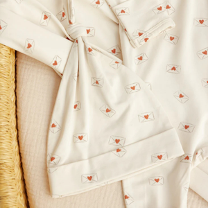 Close-up of a white fabric with red heart patterns on a textured surface.