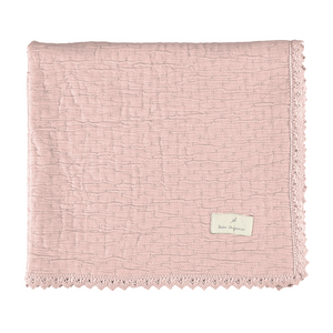 Pink textured blanket with a brand label on a white background