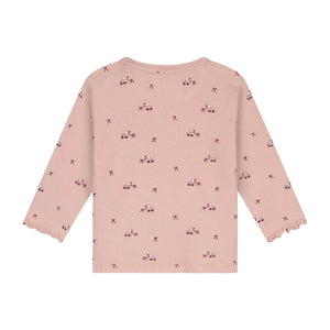 A pink long-sleeve knit top for toddlers, featuring a repeating pattern of small pink and purple flowers with star accents, displayed against a solid white background.
