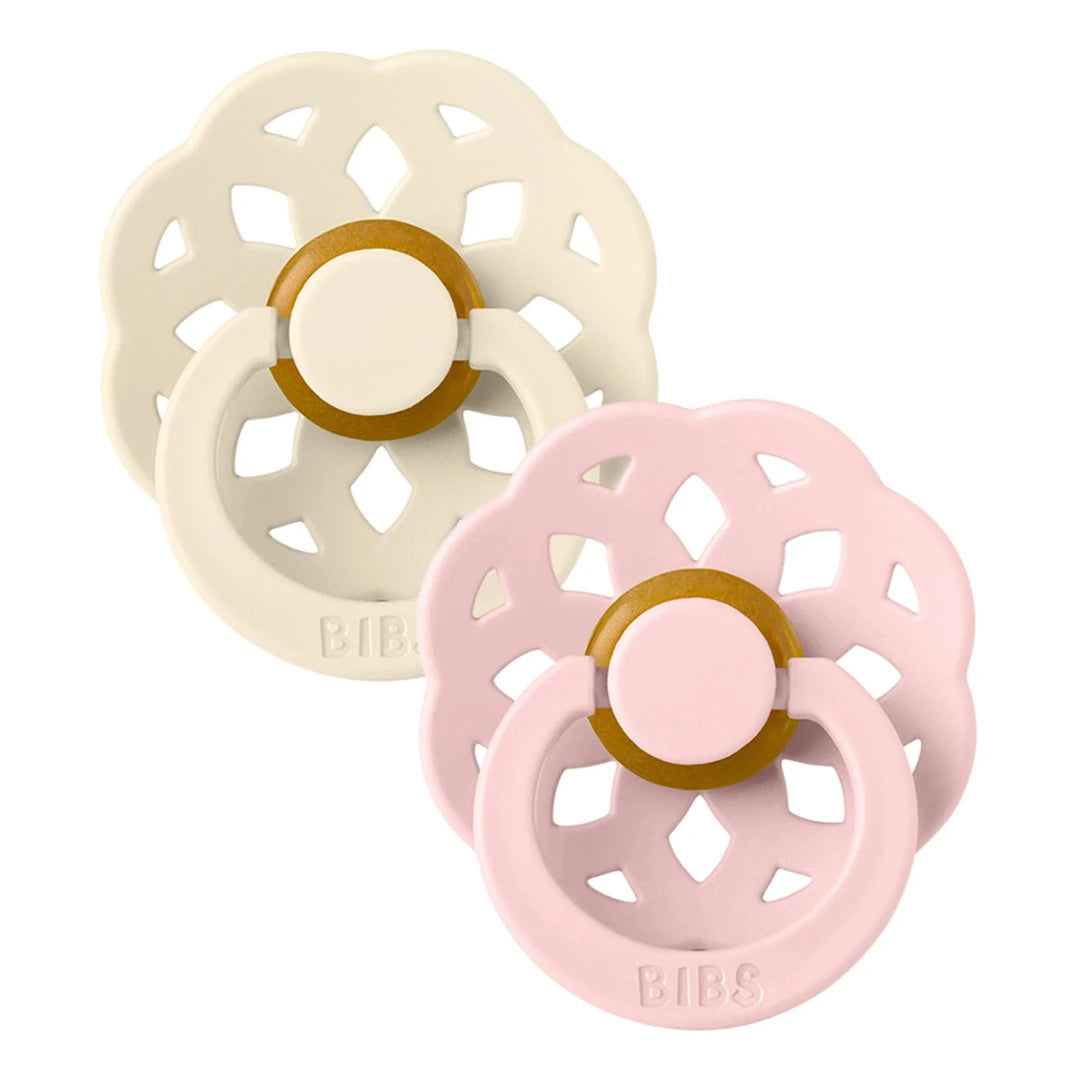 Two baby teething rings, one beige and one pink, on a white background.