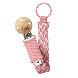 Pink pacifier clip with wooden pacifier on a white background