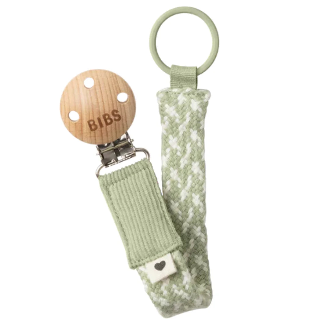 Green pacifier clip with wooden base on a white background