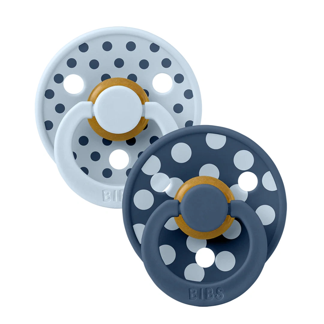 Two baby pacifiers with polka dot design on a white background