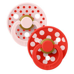 A breathtaking BIBS Studio Colour Pacifier 2-Pack in Polka Blossom and Candy Apple, showcasing its high-contrast shield and premium round natural rubber nipple.