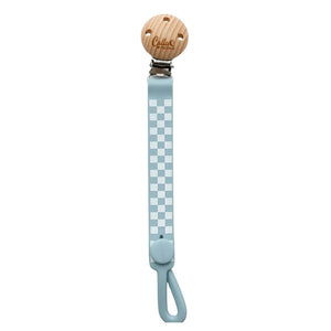 Pacifier clip with checkered strap and wooden buckle on a white background