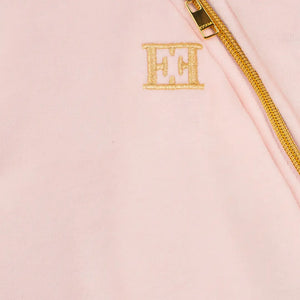 Pink pouch with gold zipper and initials 'EH' on a light pink background