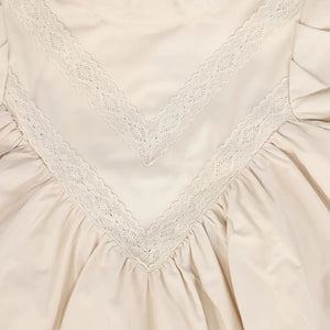 A high-resolution close-up of the crisp taffeta texture and intricate lace V-pattern.