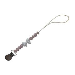 A sophisticated Three Hearts & Co. Coquette Bow Pacifier Clip in a soft neutral cotton finish, showcasing the architectural bow and premium clip detail.