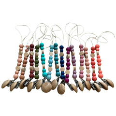 Set of colorful baby teething necklaces with wooden and silicone beads on a white background