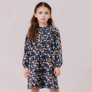 A young girl wearing the Kipp chocolate floral dress during an autumn family gathering.