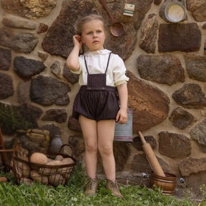 An infant wearing the La Nina brown baby pinstripe formal set comfortably during a special celebration.