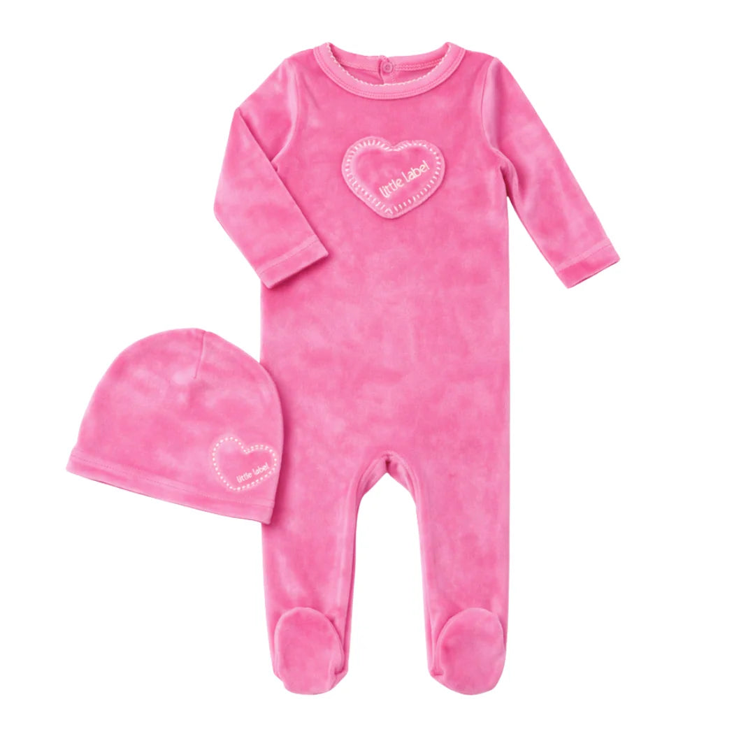 A front view of the Little Label hot pink velour baby footie and matching hat with heart detail.