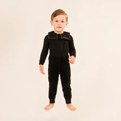 A child styled in the Little Parni black velour overall set during an outing.