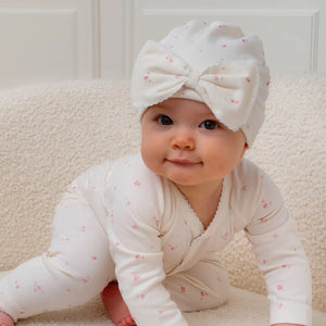 A baby girl wearing the Livly rose garden bow hat for a classic, sophisticated boutique look.