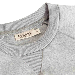 A high-resolution close-up of the plush fleece texture, collar, and signature logo detail.