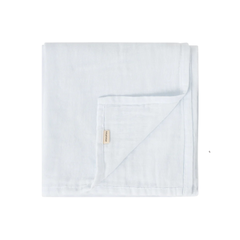 A folded light blue muslin blanket with a small beige fabric brand tag, shown on a plain white background.