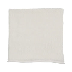 A flat-lay view of the Mema Knits ivory embroidered edge knit blanket.