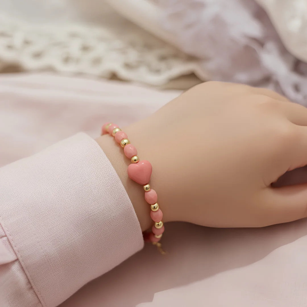 hand wearing pink beaded bow bracelet