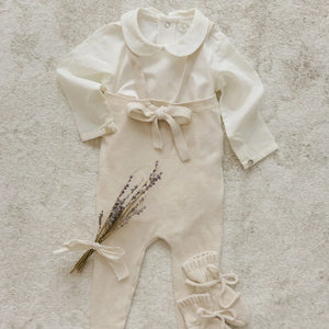 An infant styled in the Peluche Bebe long sleeve bodysuit during a family visit.