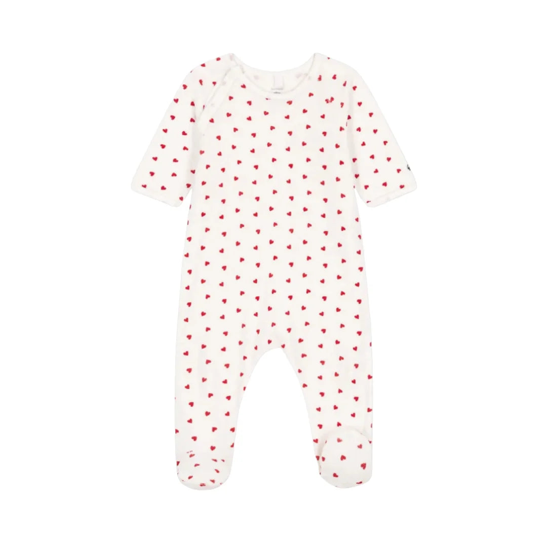 A front view of the soft white Petit Bateau velour footie with red heart prints and side snaps.