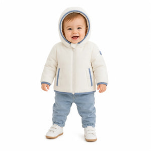 An infant styled in the Pramie blue binding jacket during an outdoor outing.