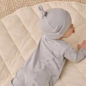 An infant resting peacefully while wearing the Quincy Mae cloud knotted baby hat.