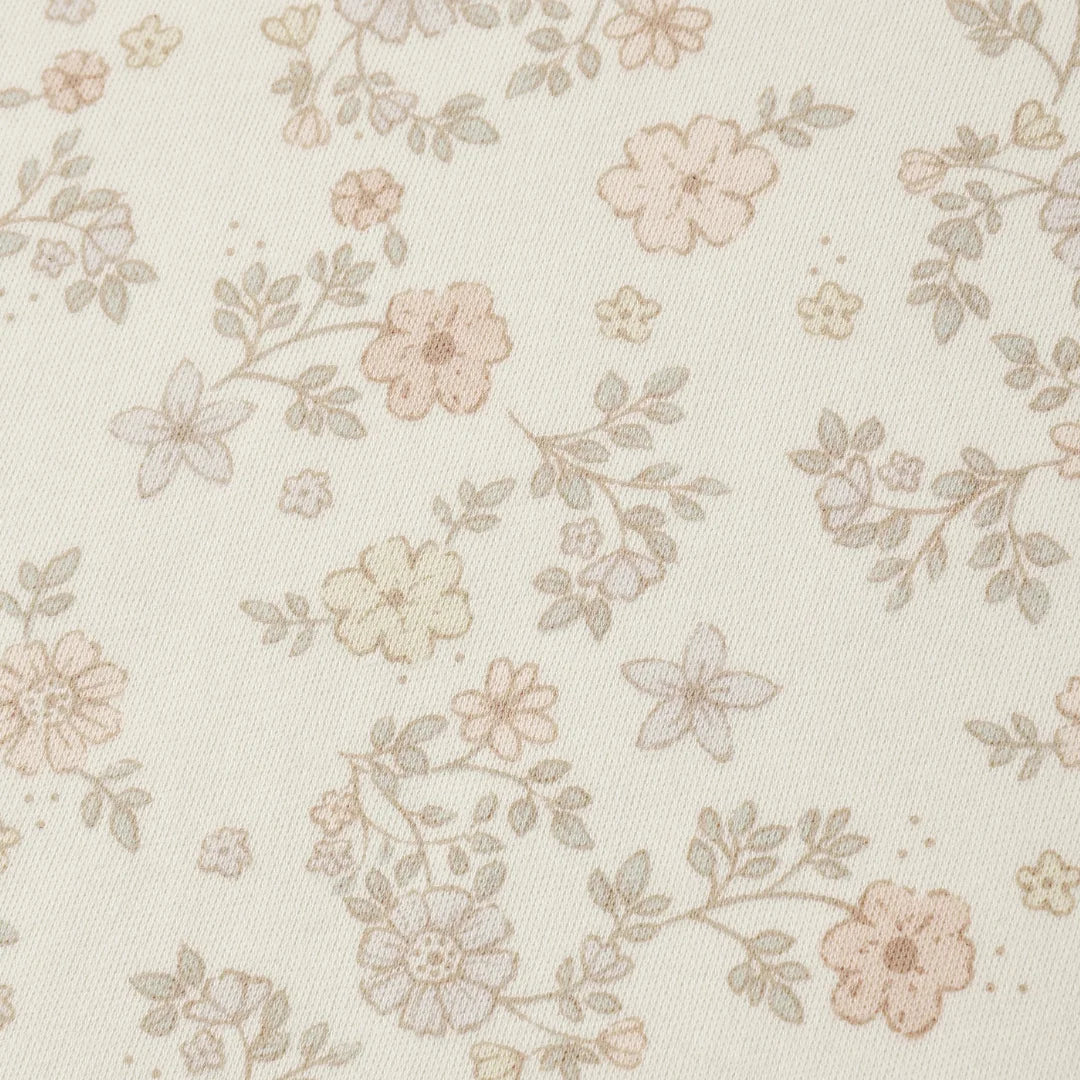 A high-resolution close-up of the breathable organic cotton texture and vine floral print.