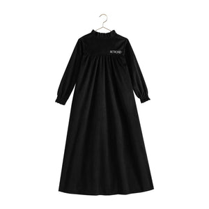 The back view of the black velvet RetroKid Isla maxi dress, highlighting its smooth, sweeping drape.