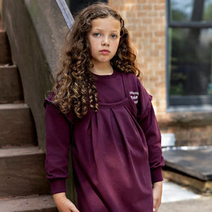A child wearing the Rooie and Friends mauve sweatshirt during an outdoor playground adventure.