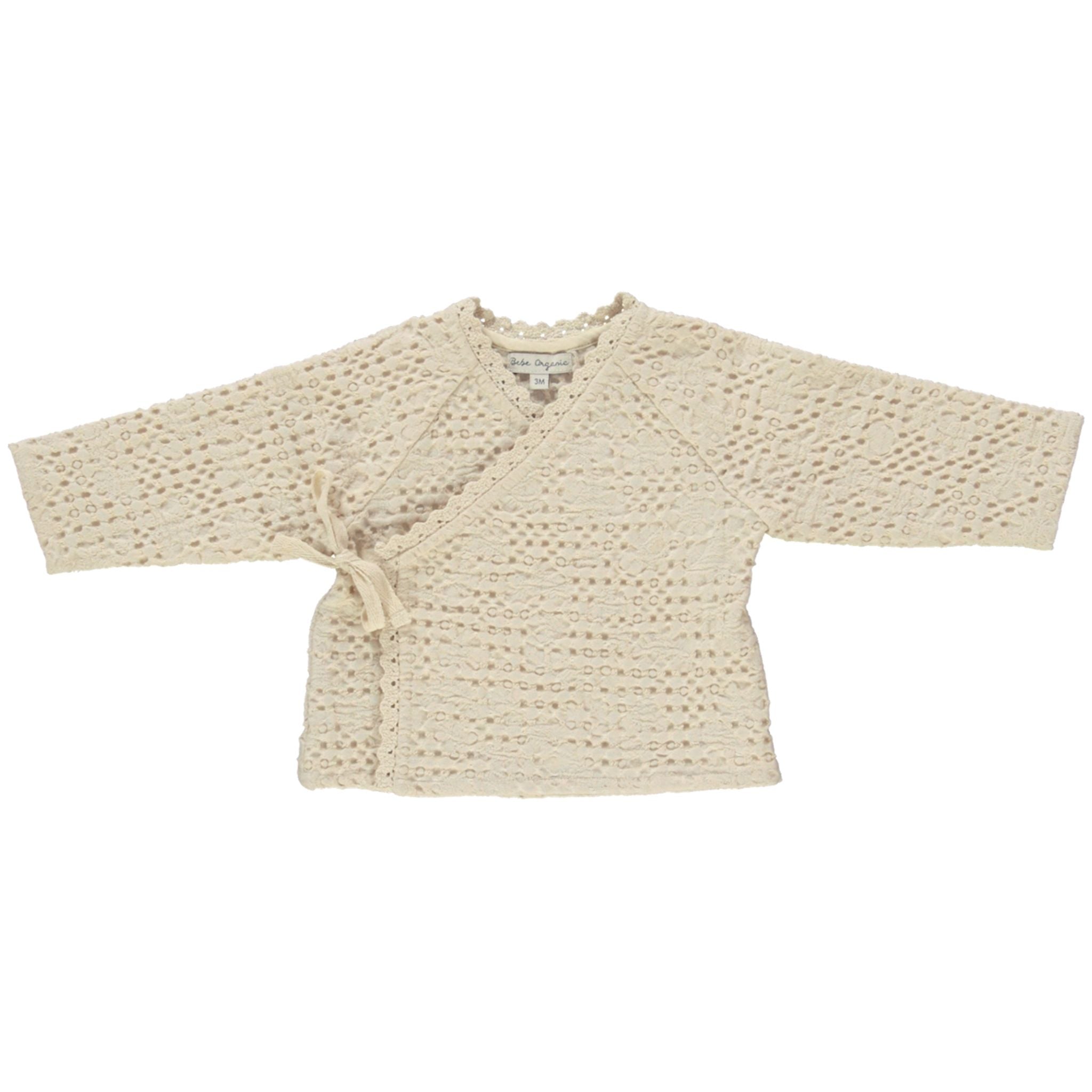 Beige knitted baby cardigan on a white background