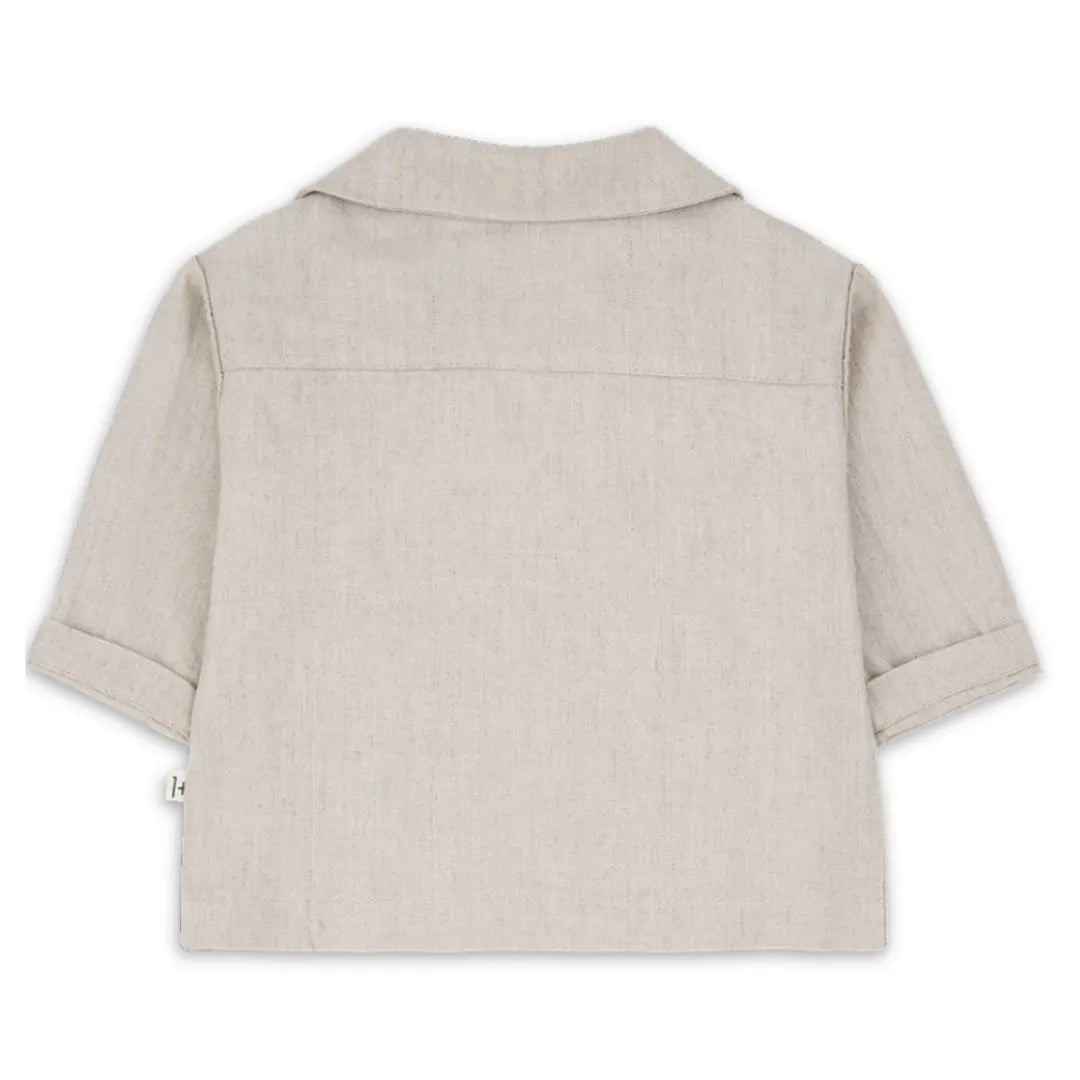 A sophisticated 1+ in the Family Jacket in a muted beige tone, showcasing its structured silhouette and high-end boutique finish.