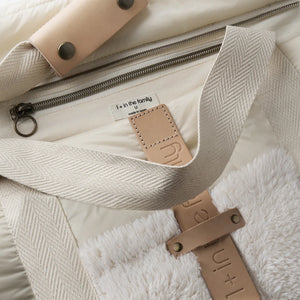 A sleek, neutral ecru 1+ in the Family maternity diaper bag styled for everyday use inside