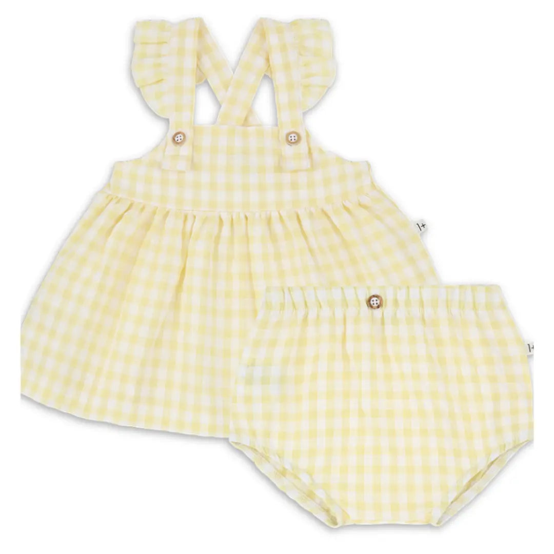 A sophisticated 1+ in the Family Rhodes Dress and matching Bloomer set in a soft neutral tone, showcasing its architectural silhouette and luxe texture.