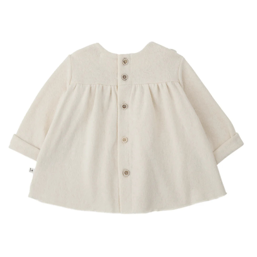 A soft, flowy 1+ in the Family TALENCE dress for babies and toddlers in a natural ecru color.
