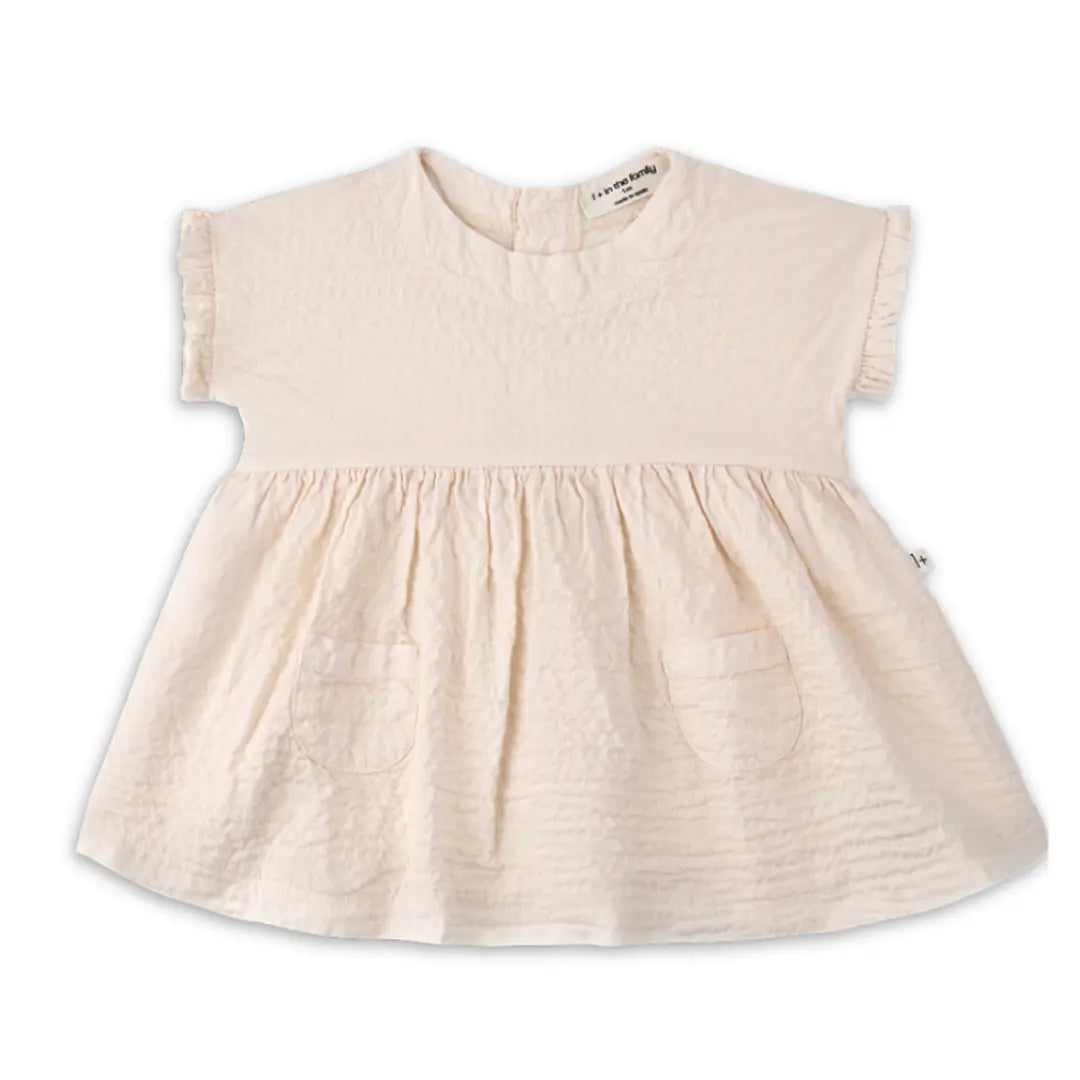 A minimalist 1+ in the Family Troya Dress in a neutral tone, featuring a high-volume flared silhouette and premium textured fabric.