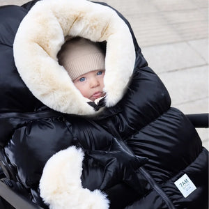 An infant resting comfortably in a car seat fitted with the 7AM Enfant cocoon during a cold winter day.