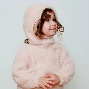 A child wearing the 7AM Enfant fleece bonnet comfortably