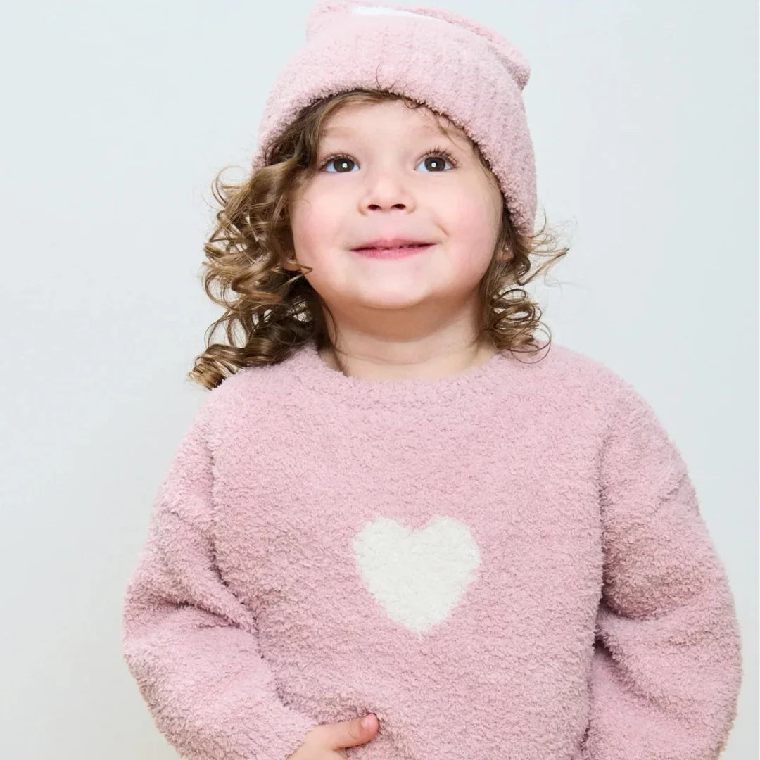 A child wearing the 7AM Enfant hood bonnet comfortably
